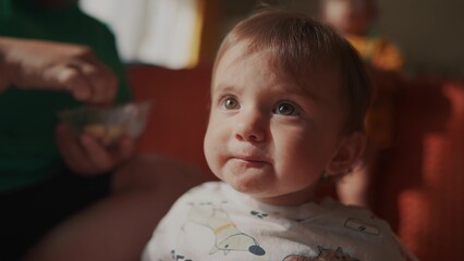 a small child eats. happy family kid dream concept. little newborn eating fruits. the small child got dirty after eating. girl in the foreground face close lifestyle up second child in the background