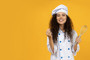 A girl in a chef uniform with a whisk in her hand