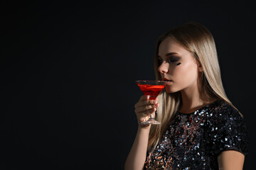 A girl at a party in the style of Halloween with a cocktail in her hands