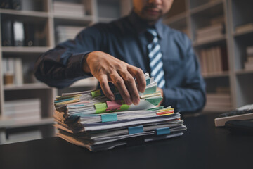 Startup company employees are rummaging through piles of paperwork for performance summaries,...