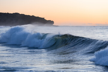 Blue breaking wave in the morning.