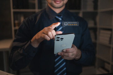 A person holds a smartphone with a product review icon on a website page to comment on the products and services received by purchasing a product from a store. Store Rating Concept