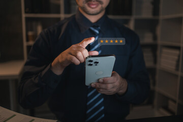 A person holds a smartphone with a product review icon on a website page to comment on the products and services received by purchasing a product from a store. Store Rating Concept