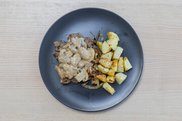 A plate of beef and potato with creamy mushroom sauce.