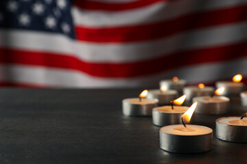 Burning candles on the table and the flag of the United States of America, space for text