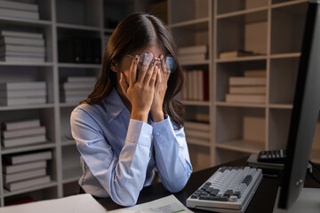 Company employees working overtime after work, working overtime after working hours due to heavy workload, employees are stressed and tired from working hard all day and continuously working overtime.