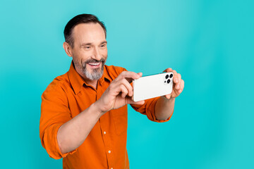Photo of satisfied handsome man with gray white beard making photo on smartphone look empty space...