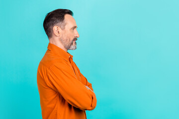Side profile photo of optimistic man with white gray beard wear stylish shirt look empty space at promo isolated on teal color background