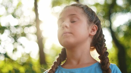 child closed eyes. little girl closed her a eyes dreaming about the future in the forest in nature in the park. happy family kid dream concept. happy family kid dream concept lifestyle