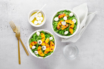 Grilled Peach Salad with Arugula and Mozzarella on Bright Concrete Background