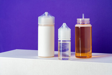 Electronic cigarettes liquid bottles on purple background
