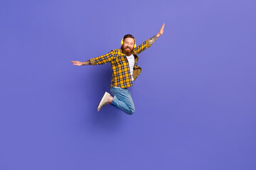 Fototapeta na wymiar Full length photo of glad positive man wear trendy outfit fly ait rejoice listen playlist wireless device isolated purple color background