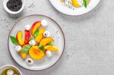 Grilled Peach Salad with Mozzarella Pearls on Bright Concrete Background