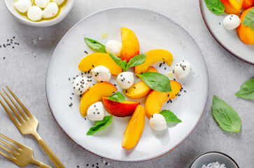 Grilled Peach Salad with Mozzarella Pearls on Bright Concrete Background