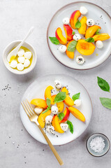 Grilled Peach Salad with Mozzarella Pearls on Bright Concrete Background