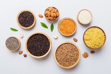 Various superfoods in smal bowl on colored background. Superfood as rice, chia, quinoa, lentils, nuts, sesame seeds, almonds. top view copy space