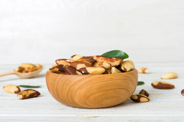 Fresh healthy Brazil nuts in bowl on colored table background. Top view Healthy eating bertholletia concept. Super foods