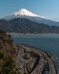 A beautiful view of mount fuji with a blue skies and a highway and the sea of japan. - obrazy, fototapety, plakaty