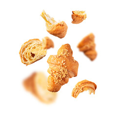 Creative bakery food background, croissant sprinkled with nuts. Cut out flying whole and broken fresh croissant with butter cream isolated on white background. With clipping path