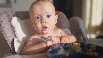 baby dirty eats. happy family a child toddler concept. baby dirty lifestyle sitting messing with...