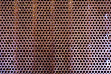 close up of a metal grate with small round holes - background for use as a texture
