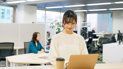 Obraz premium オフィスで仕事するカジュアルな女性