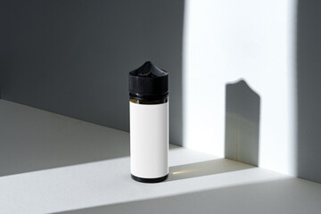 Dropper bottle with vape liquid on white background in the sunlight with shadows