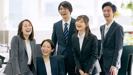 オフィスで大笑いするビジネスパーソンのグループ