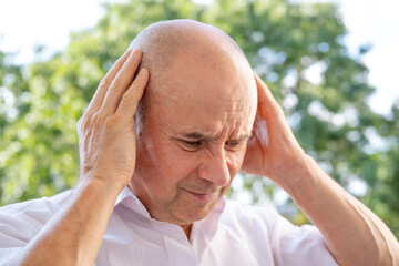 senior, mature man 50-55 years old holds on nape, temples, close up male face with facial...