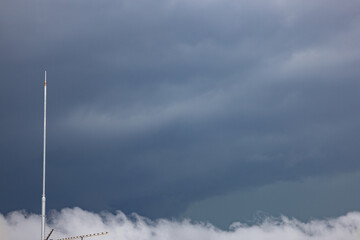都会の夏・秋の空・竜巻が発生しそうな嵐の雨雲が広がる空と避雷針と都会のビル（東京都千代田区） - obrazy, fototapety, plakaty
