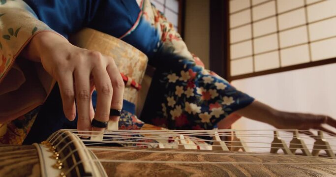 Mesmerizing Close Up of an Anonymous Female Playing a Traditional Japanese String Instrument. Focus on Hands of a Koto Musician, Performing Beautiful Historic Music on Stage