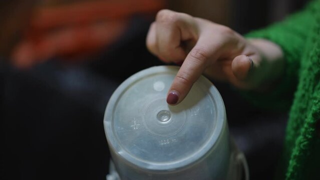 Closeup white plastic cap with 5 pp symbol and female finger pointing. Close-up used trash for recycling indoors