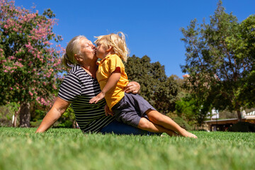 grandmother and grandson are walking in the park on a summer day