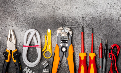 Electrician equipment on black textured background with copy space.Top view.Electrician tool set.Multimeter, tester,screwdrivers,cutters,duct tape,lamps,tape measure and wires.Flet lay.Concept buildin © Avocado_studio