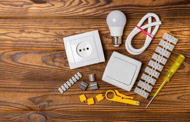 Electrician equipment on a wooden background with copy space.Top view.Electrician tool set.Multimeter, tester,screwdrivers,cutters,duct tape,lamps,tape measure and wires.Flet lay.Concept building © Avocado_studio