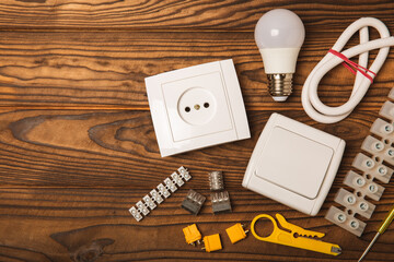 Electrician equipment on a wooden background with copy space.Top view.Electrician tool set.Multimeter, tester,screwdrivers,cutters,duct tape,lamps,tape measure and wires.Flet lay.Concept building © Avocado_studio