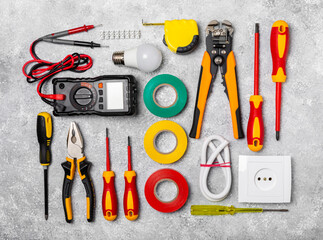 Electrician equipment on marble background with copy space.Top view.Electrician tool set.Multimeter, tester,screwdrivers,cutters,duct tape,lamps,tape measure and wires.Flet lay. Construction concept. © Avocado_studio