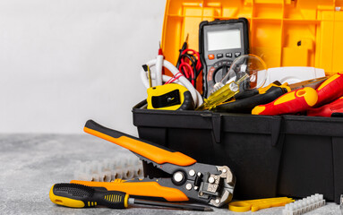 Electrician equipment on marble background with copy space.Top view.Electrician tool set.Multimeter, tester,screwdrivers,cutters,duct tape,lamps,tape measure and wires.Flet lay. Construction concept. © Avocado_studio