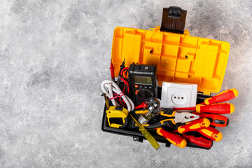 Electrician equipment on marble background with copy space.Top view.Electrician tool set.Multimeter, tester,screwdrivers,cutters,duct tape,lamps,tape measure and wires.Flet lay. Construction concept. © Avocado_studio