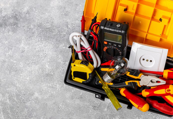 Electrician equipment on marble background with copy space.Top view.Electrician tool set.Multimeter, tester,screwdrivers,cutters,duct tape,lamps,tape measure and wires.Flet lay. Construction concept. © Avocado_studio