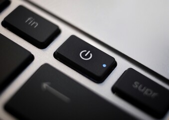 Black power button closeup on laptop keyboard