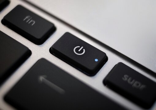 Black power button closeup on laptop keyboard