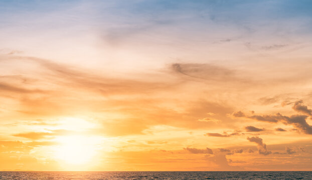 Sunset Sky over Horizon seascape in the evening with Orange, Yellow sunlight Clouds, Golden Hour landscape Background  