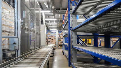 Automatic conveyor system with lift and gravity racks in warehouse