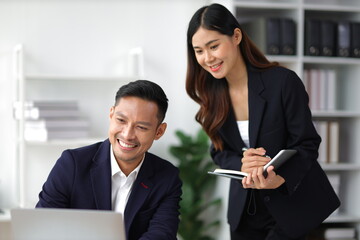 Boss and secretary working on documents together in office. Businessman and colleagues discussing in office collaboration.