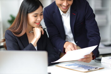 Boss and secretary working on documents together in office. Businessman and colleagues discussing in office collaboration.
