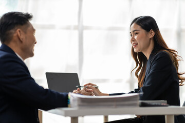 Boss and secretary working on documents together in office. Businessman and colleagues discussing in office collaboration.