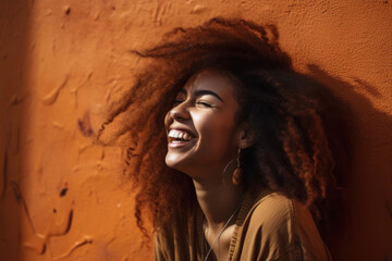 Portrait of beautiful african american woman laughing and smiling in sun rays outdoor