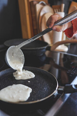 Ladle with dough for pancakes and a frying pan