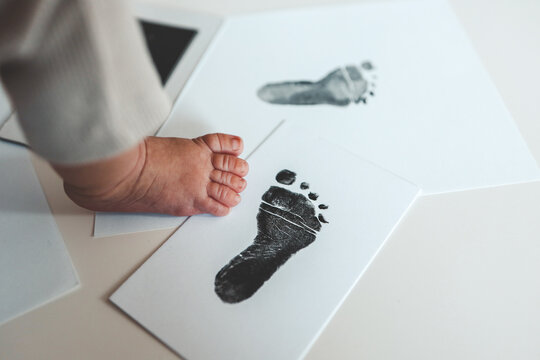 Baby footprints on white paper. Black footprint. The process of creating a baby footprint